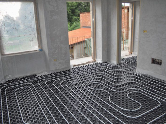 Heating pipes laid out on floor in building under construction