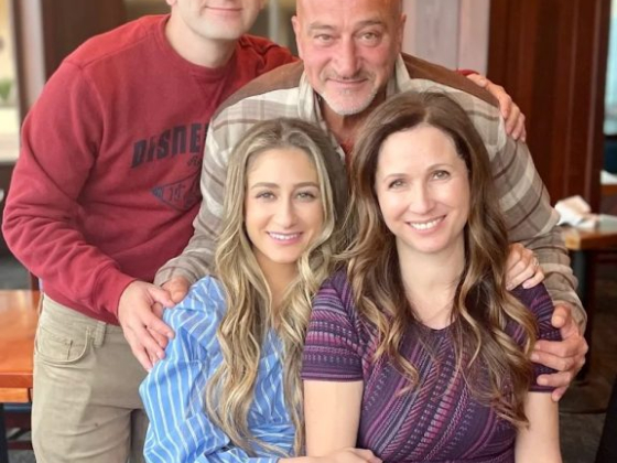 Four people posing for a cheerful photo indoors