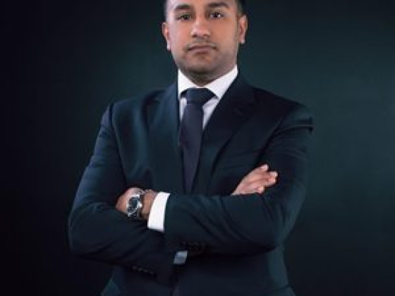 Confident man posing with arms crossed in suit