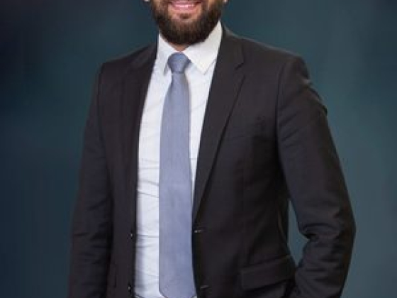 Man smiling while wearing a formal business suit