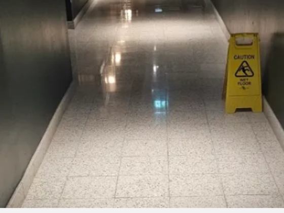 Polished stone floor with caution sign in hallway