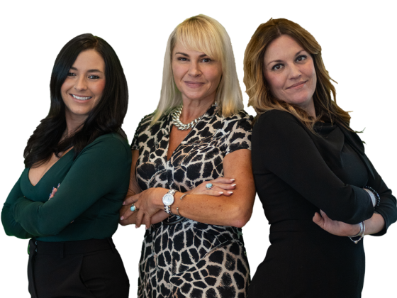 Three confident women posing together in stylish attire