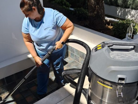 Vacuuming tiles in a garden area with specialized equipment