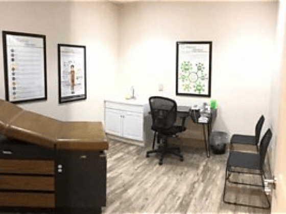 Neatly arranged medical room with chairs and exam table