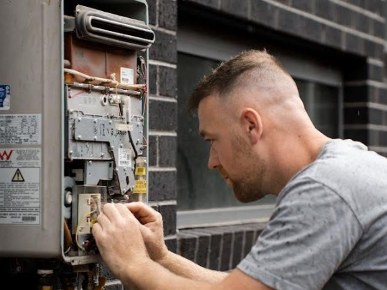 Person working on a wall-mounted device