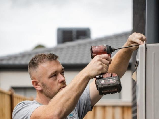 Man drilling into wall with red power drill