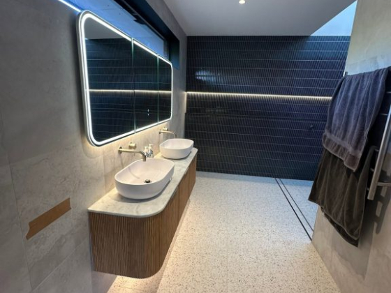 Spacious bathroom featuring twin sinks and stylish lighting