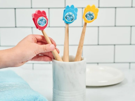Hand arranging toothbrushes with animal designs