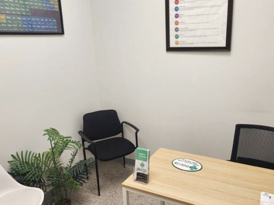 An office with a desk, chairs, and educational posters on the walls