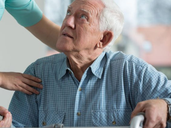 Senior man receives help from caregiver at home