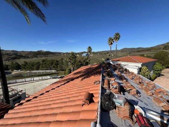 Ongoing roof repair with stacked tiles and tools
