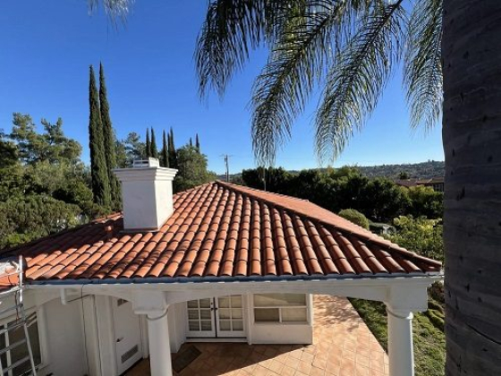House with red tile roof under clear blue sky