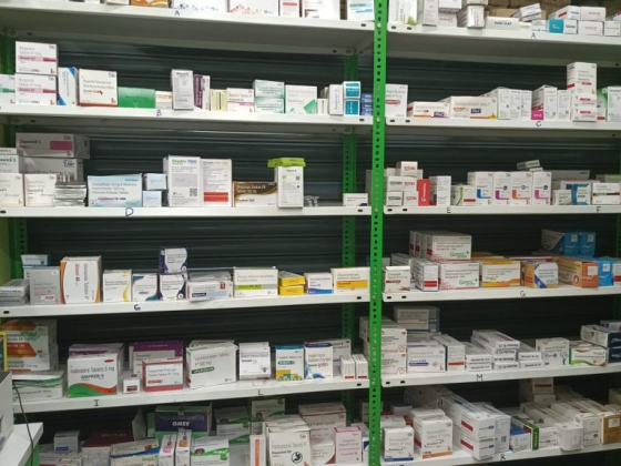 Pharmacy shelves filled with assorted medicine boxes and labels